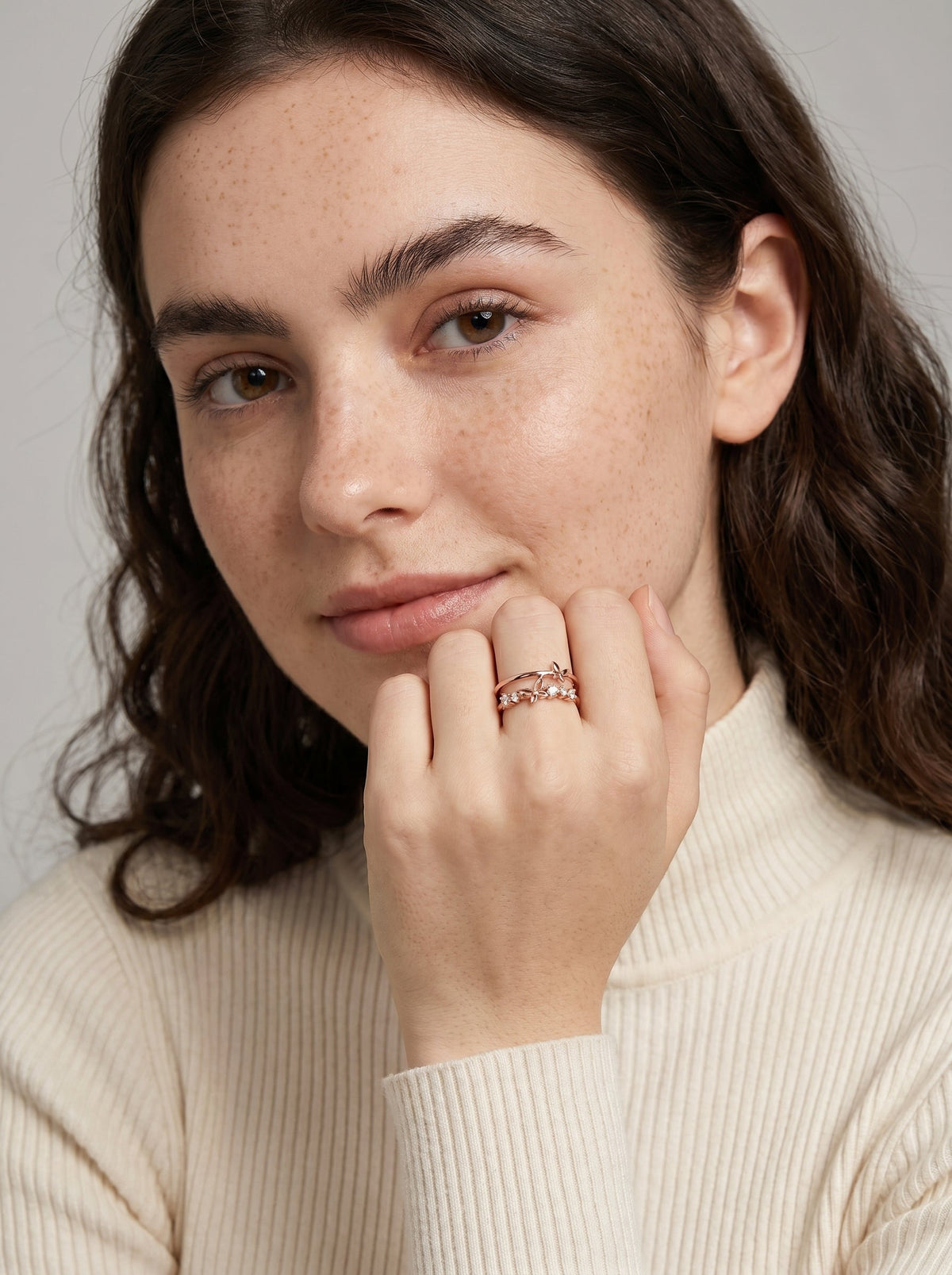 Mujer con un anillo rosa sobre un fondo neutro

