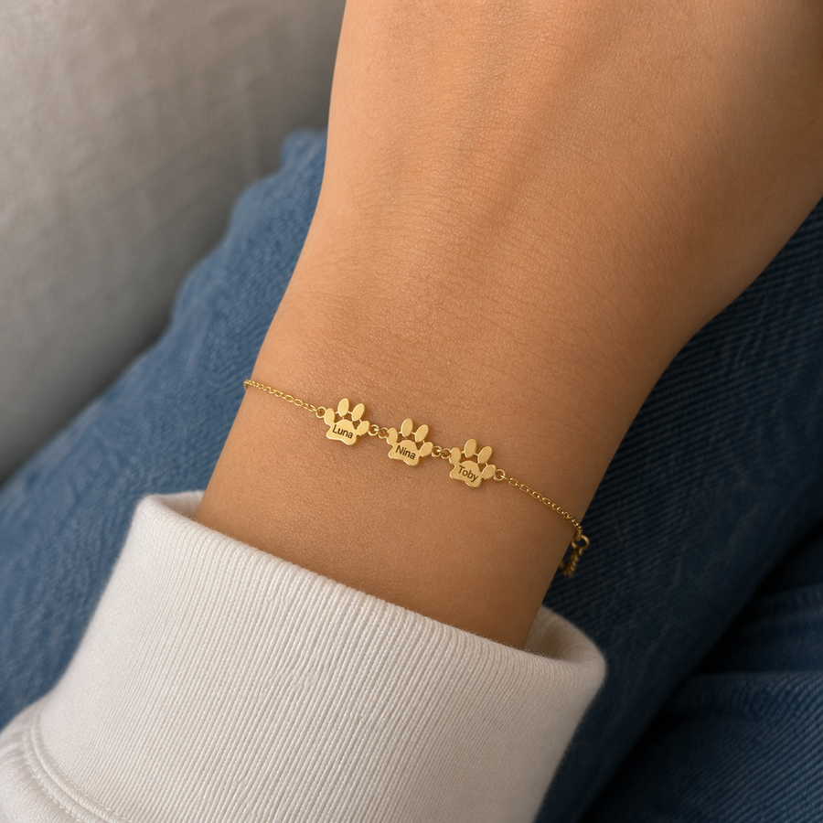 Pulsera con Huellas y nombres dorada — 3 Huellas con los nombres Luna, Nina y Toby en la muñeca — lifestyle realista