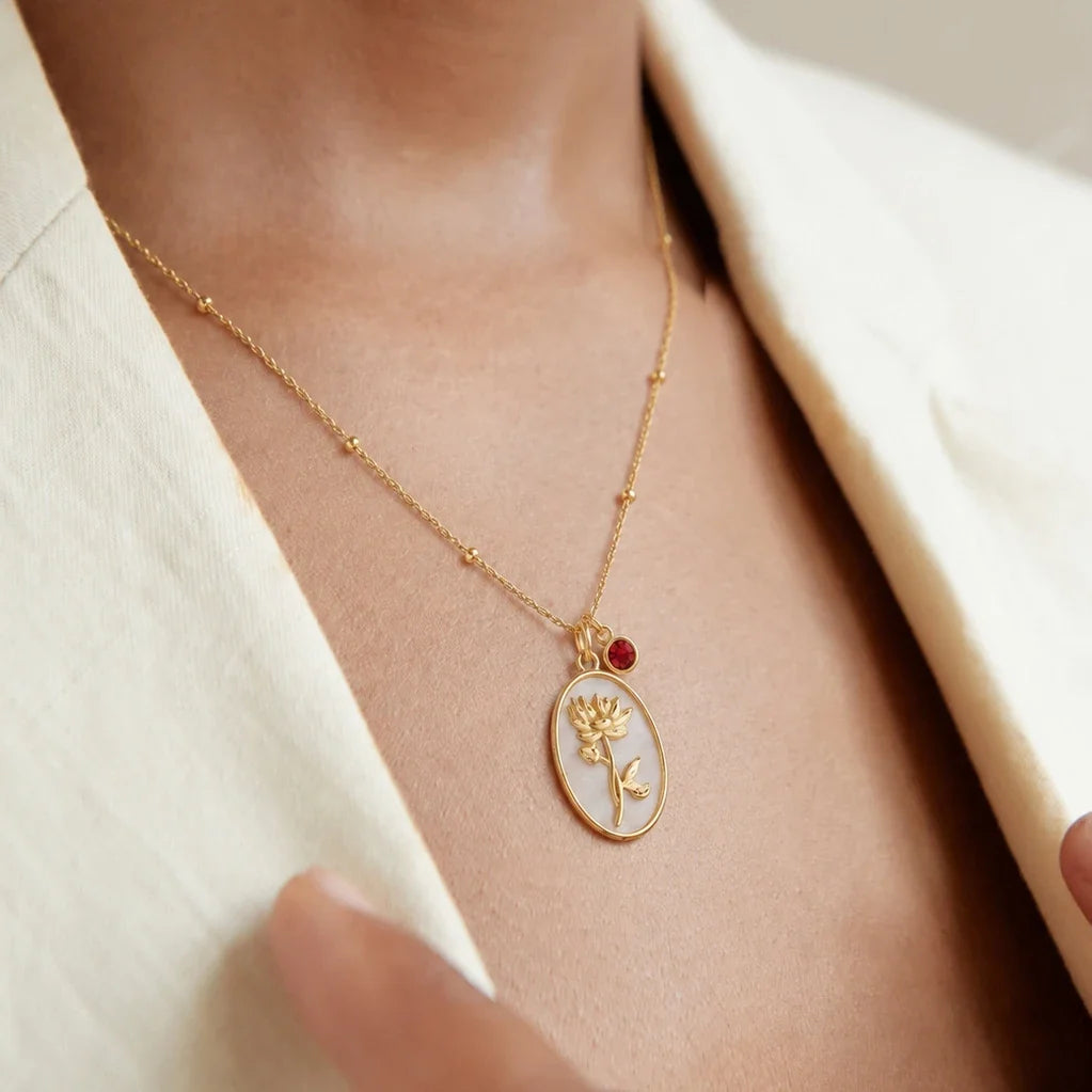 Collar flor del mes dorado en el modelo — piedra roja