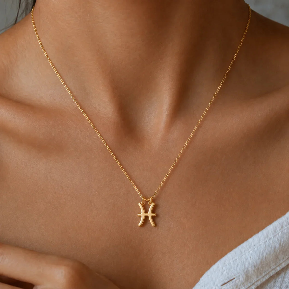 Collar signo Piscis dorado en el modelo — símbolo del zodiaco