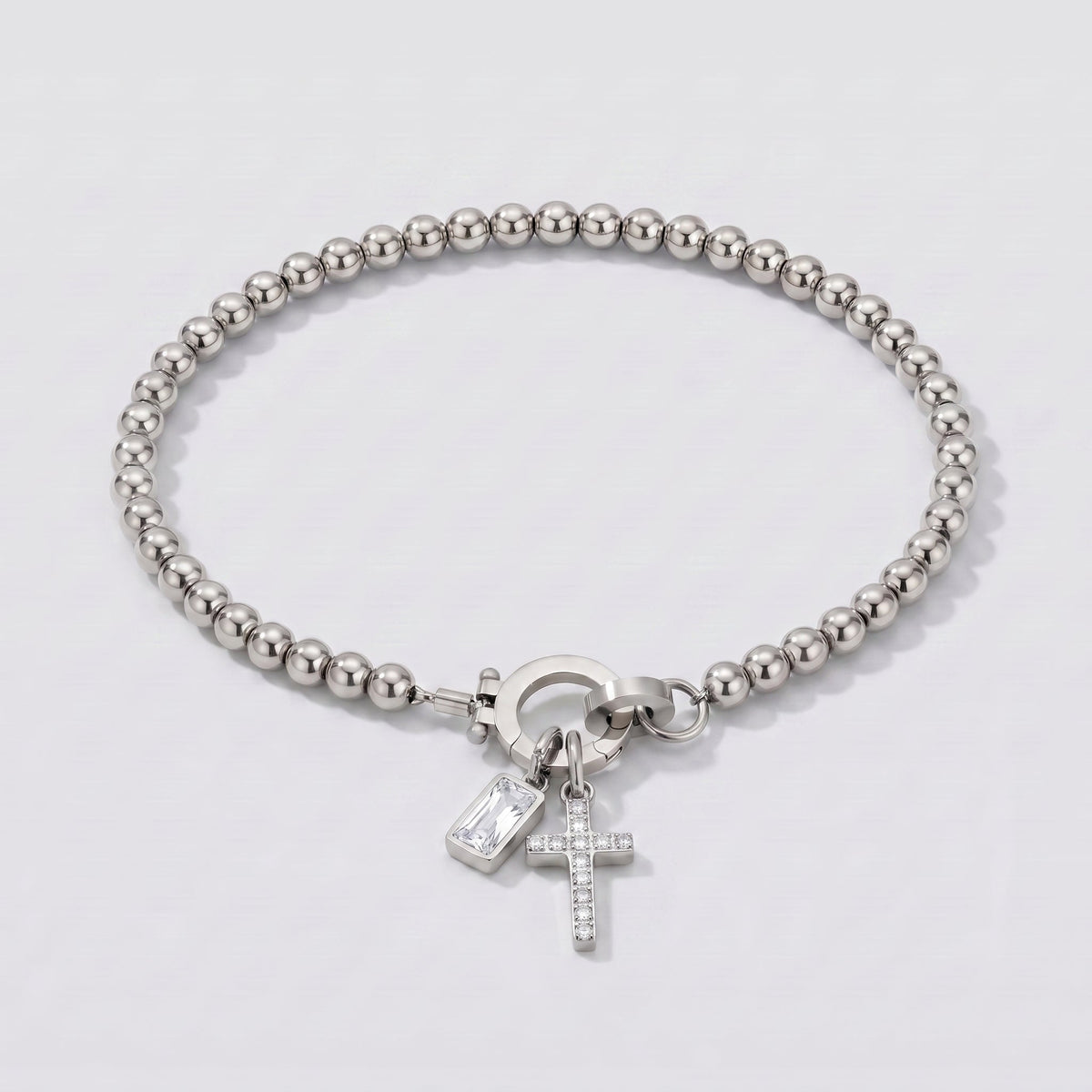 Pulsera plateada de cuentas con cruz y piedra de nacimiento diamante transparente de abril.
