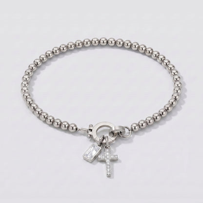 Pulsera plateada de cuentas con cruz y piedra de nacimiento diamante transparente de abril.