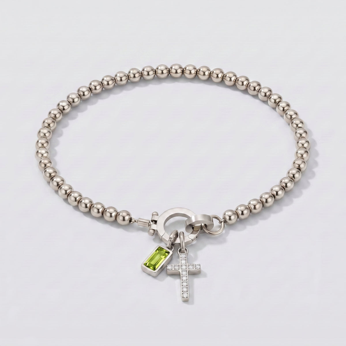 Pulsera plateada de cuentas con cruz y piedra de nacimiento peridoto verde de agosto.
