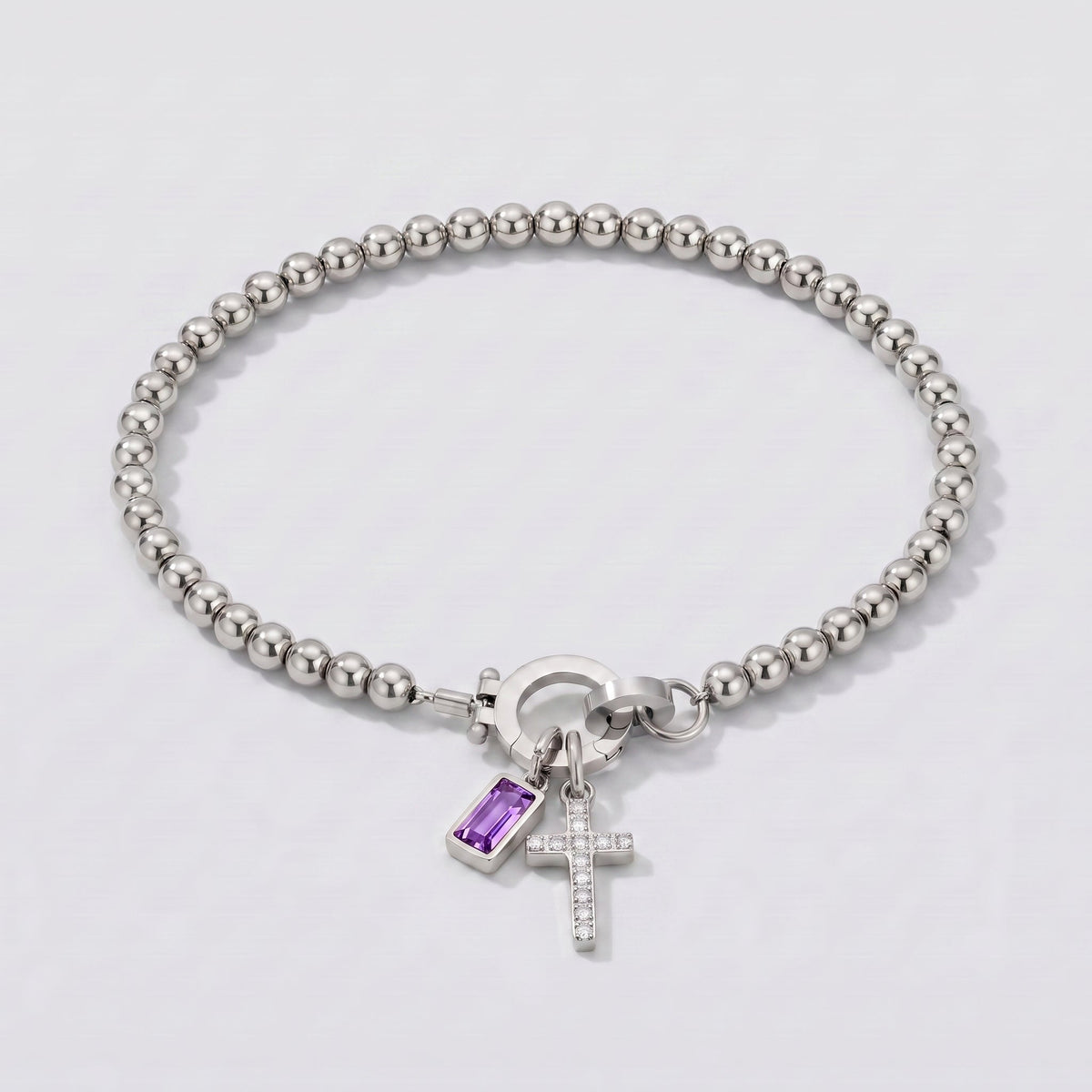 Pulsera plateada de cuentas con cruz y piedra de nacimiento amatista morada de febrero.