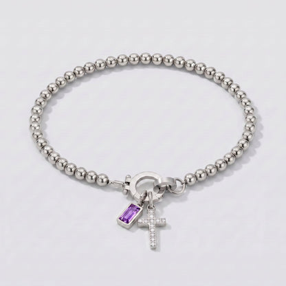 Pulsera plateada de cuentas con cruz y piedra de nacimiento amatista morada de febrero.