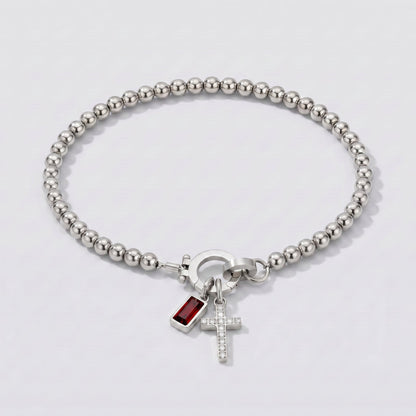 Pulsera plateada de cuentas con cruz y piedra de nacimiento granate rojo de enero.