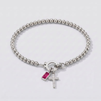 Pulsera plateada de cuentas con cruz y piedra de nacimiento rubí rojo de julio.