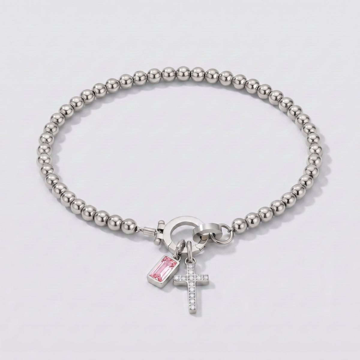 Pulsera plateada de cuentas con cruz y piedra de nacimiento turmalina rosa de octubre.