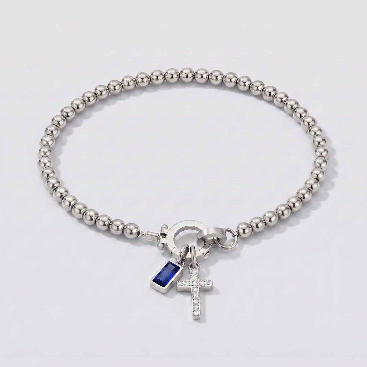 Pulsera plateada de cuentas con cruz y piedra de nacimiento zafiro azul de septiembre.