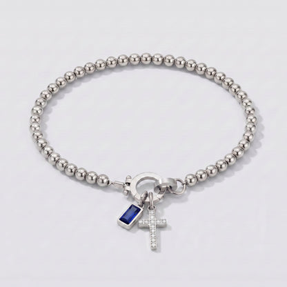 Pulsera plateada de cuentas con cruz y piedra de nacimiento zafiro azul de septiembre.
