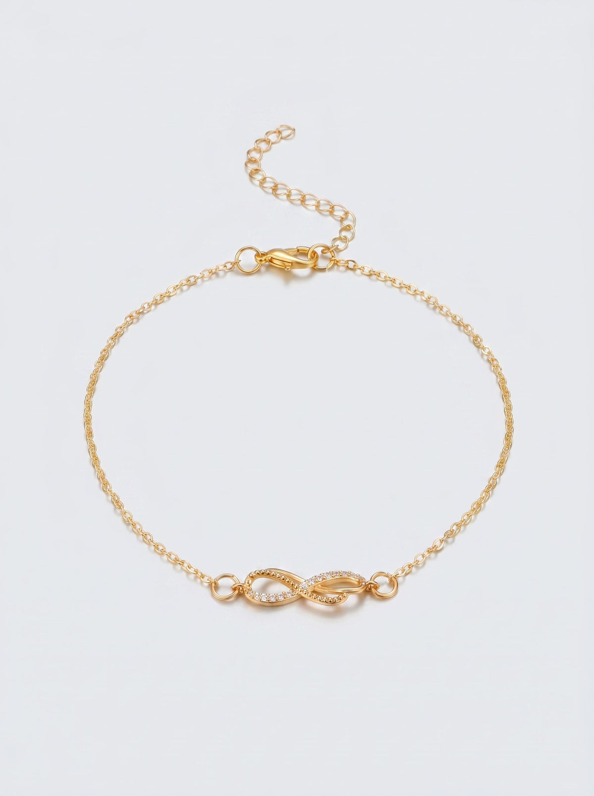 Pulsera dorada delicada con símbolo infinito y acabado brillante, fotografiada sobre fondo claro para un look elegante, femenino y minimalista.