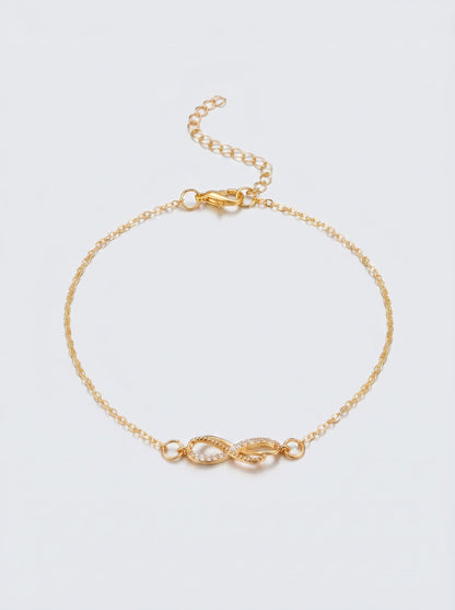 Pulsera dorada delicada con símbolo infinito y acabado brillante, fotografiada sobre fondo claro para un look elegante, femenino y minimalista.