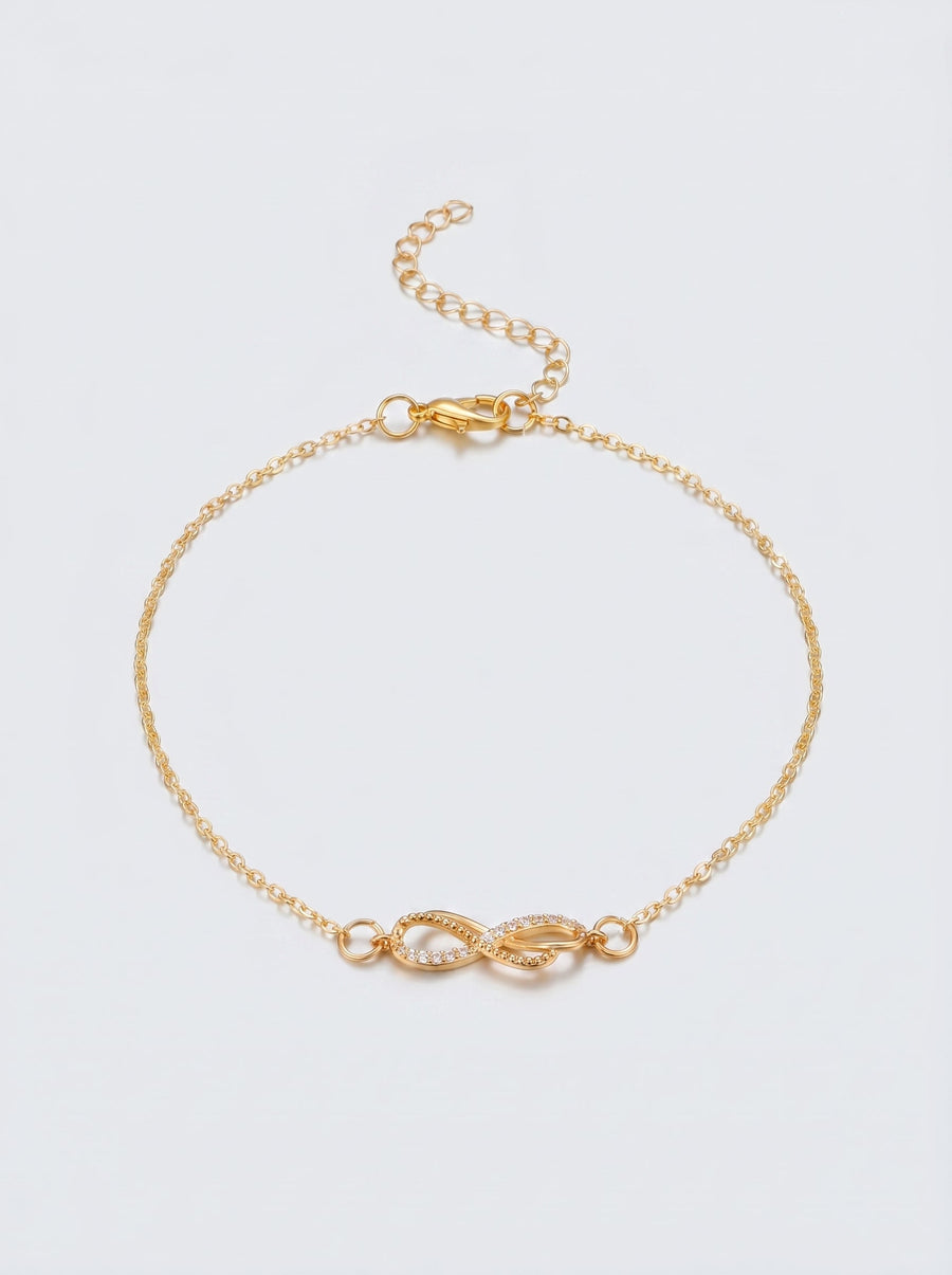 Pulsera dorada delicada con símbolo infinito y acabado brillante, fotografiada sobre fondo claro para un look elegante, femenino y minimalista.