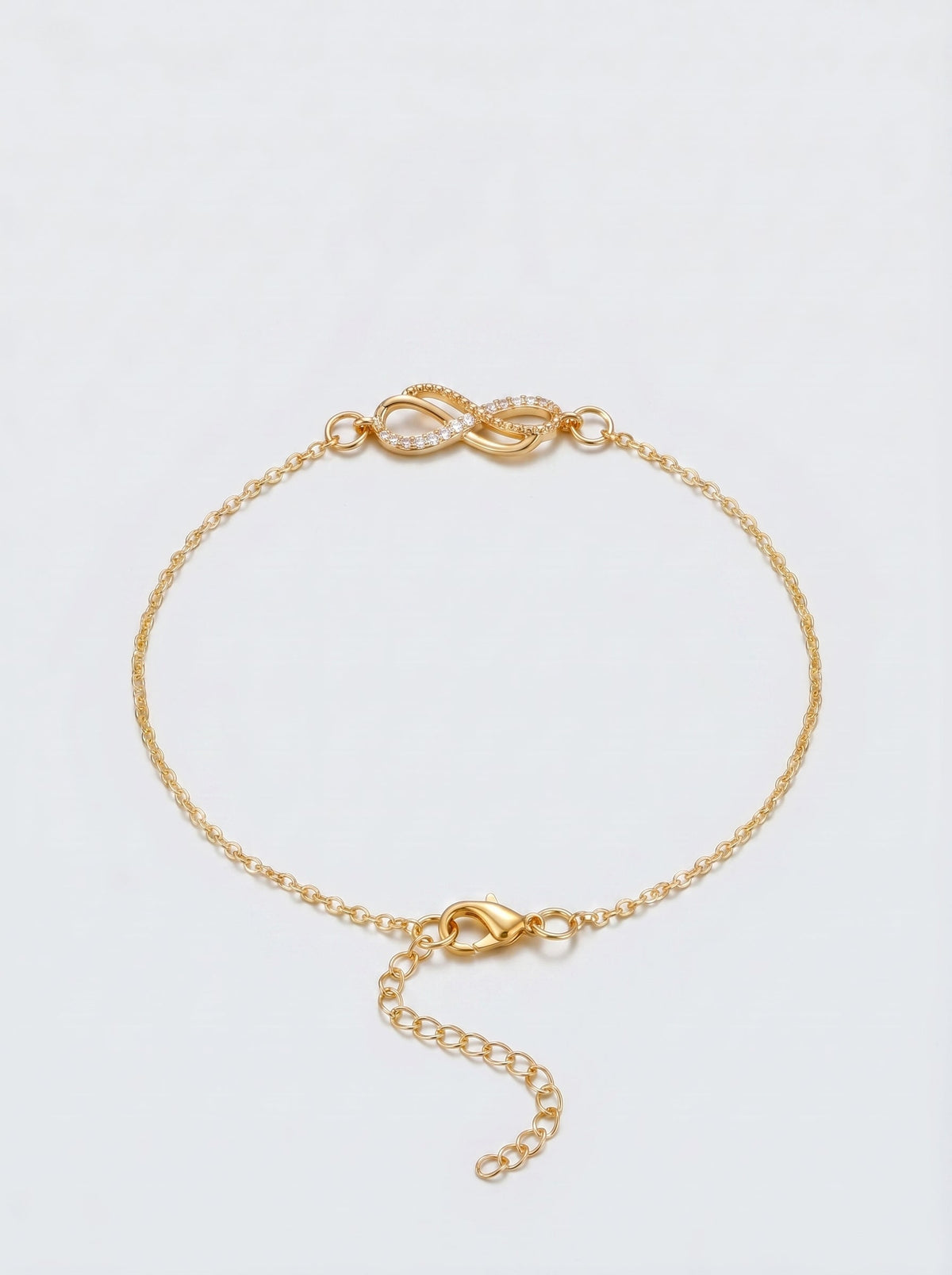 Pulsera dorada delicada con símbolo infinito, cadena fina y cierre ajustable, fotografiada sobre fondo claro para un look elegante, femenino y minimalista.