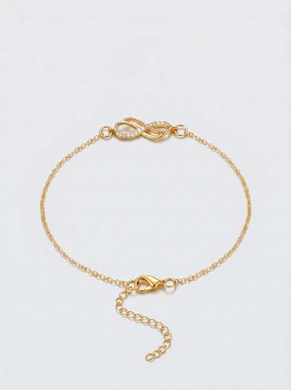 Pulsera dorada delicada con símbolo infinito, cadena fina y cierre ajustable, fotografiada sobre fondo claro para un look elegante, femenino y minimalista.