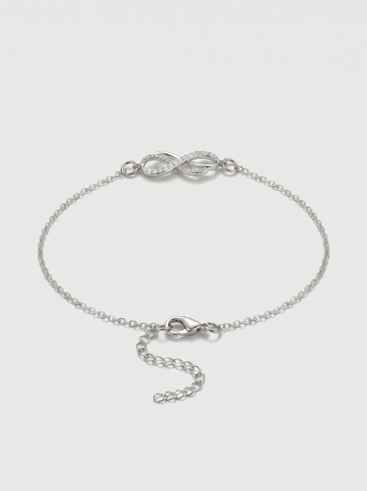 Pulsera plateada delicada con símbolo infinito, detalle en cristales, cadena fina y cierre ajustable, fotografiada sobre fondo claro para un look elegante, femenino y minimalista.