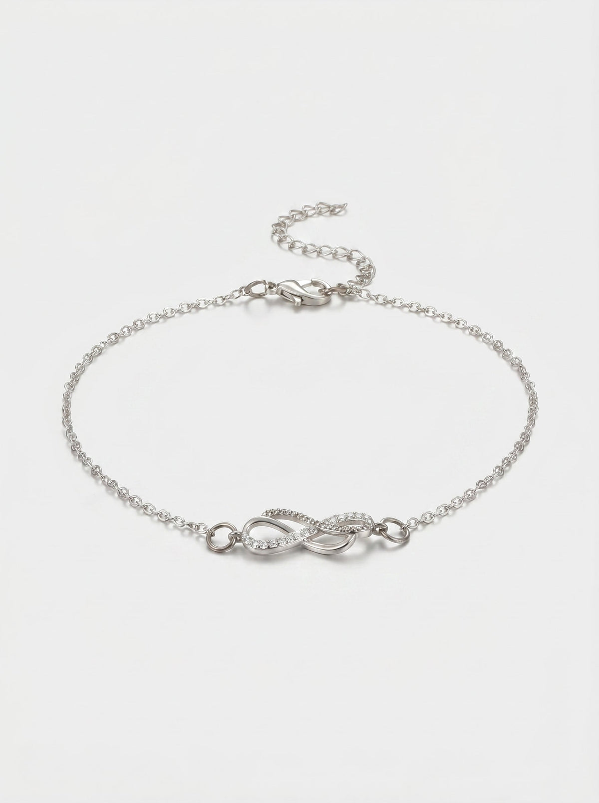 Pulsera plateada delicada con símbolo infinito, detalle en cristales, cadena fina y cierre ajustable, fotografiada sobre fondo claro para un look elegante, femenino y minimalista.