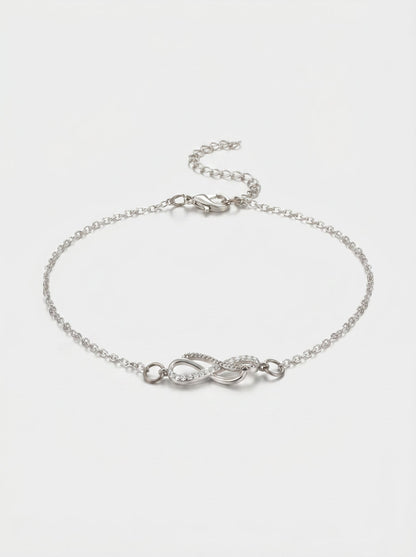 Pulsera plateada delicada con símbolo infinito, detalle en cristales, cadena fina y cierre ajustable, fotografiada sobre fondo claro para un look elegante, femenino y minimalista.