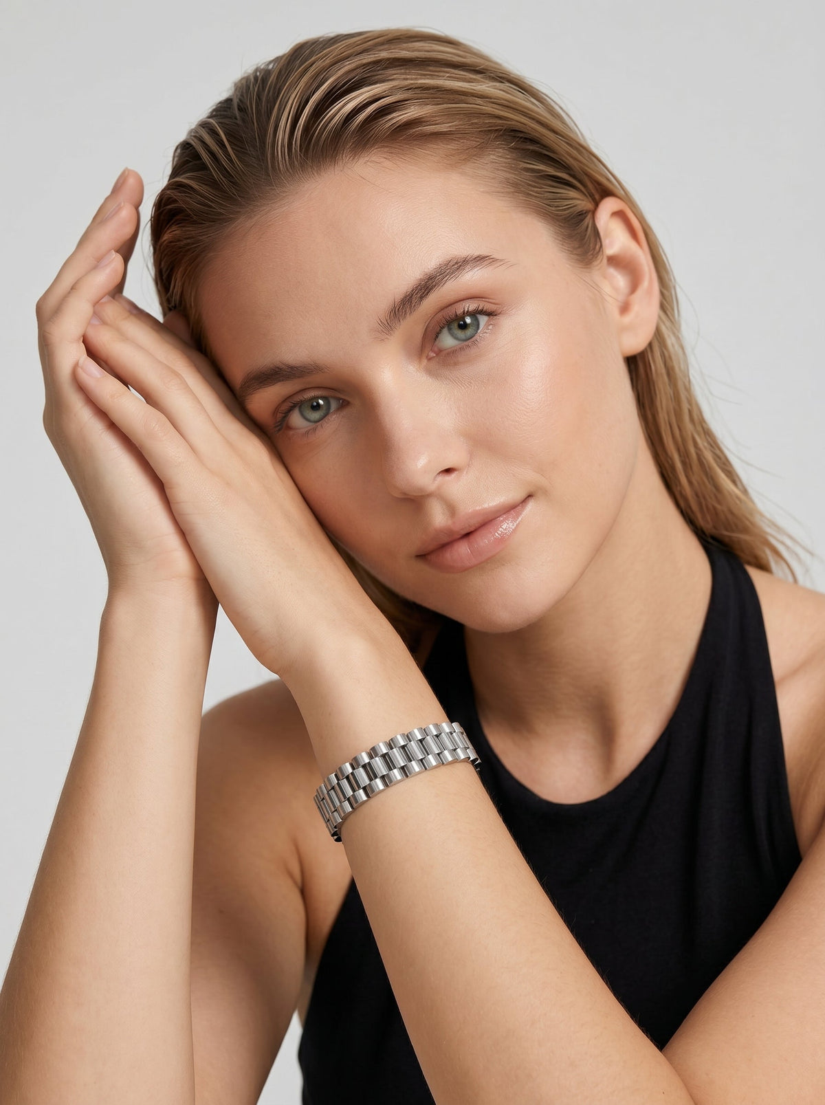 Pulsera plateada con diseño de eslabones anchos y acabado brillante, usada por una modelo para un look elegante y sofisticado.
